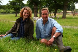 Kate Humble and Ben Fogle sitting on the grass at Longleat